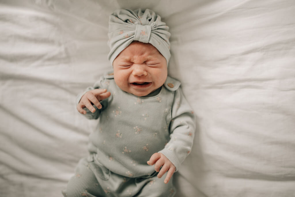 Ein Schreibaby, oder auch High Need Baby, weinend am Boden
